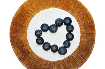 Blueberries on a plate on a white background. Signs. Healthy wholesome food. Vitamins and microelements.