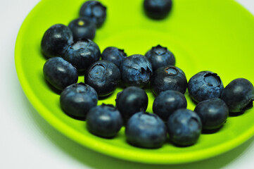 Blueberries on a plate on a white background. Signs. Healthy wholesome food. Vitamins and microelements.