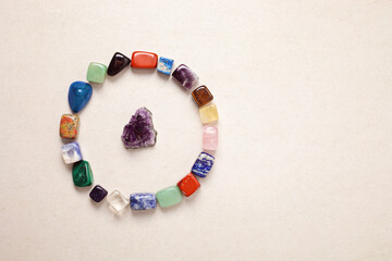 Healing reiki chakra crystals over white fabric background. Gemstones for wellbeing, harmony,...