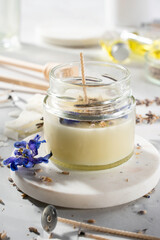 Set tools for homemade natural eco-friendly soy wax candles, wick, perfume, essential oil on a marble table. Making process. Trendy DIY. Craft hobby, small business, artisan products concept