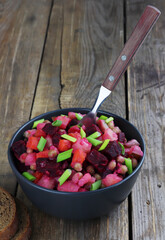 Vinaigrette traditional russian salad with boiled vegetables on wooden background with copy space