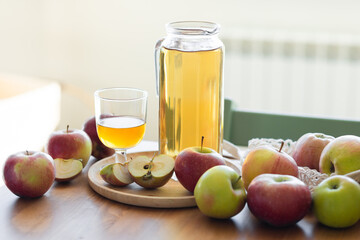 Fresh homemade organic apple juice or cider on a wooden table in a glass jug