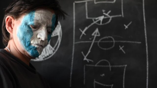 close-up of Argentine soccer fan strategizing on blackboard - Powered by Adobe