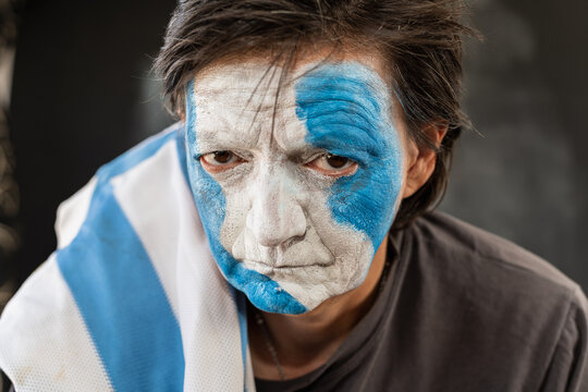 closeup of soccer fan painting the face of argentina celebrating