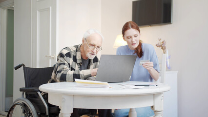 Daughter helps elderly father pay bills online