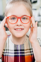 a pretty little girl in colored-rimmed glasses. glasses for children. 