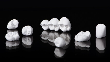 High aesthetic zirconia dentures and crowns on colorful background. Set of single dentures and...