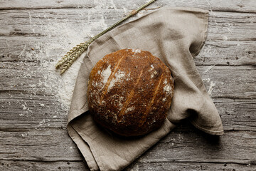 an artisan bread seen from the zenith on a rustic cloth on a rustic wooden table