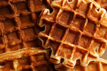 Fresh homemade sweet belgian waffles with honey and powdered sugar filling the frame