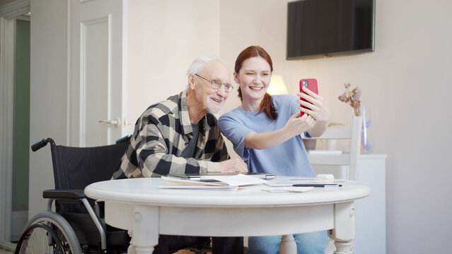  A woman takes photos with an old man. He is surprised, smiles and rejoices