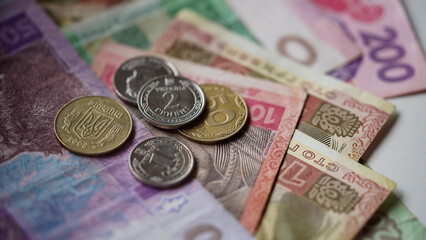 Close-up of hryvnia banknotes and coins on a white background, Ukrainian currency. The concept of currency exchange in another country. Selective focus.
