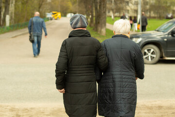 Pensioners in Russia. Women walk down the street. Grandmothers walk down the road.