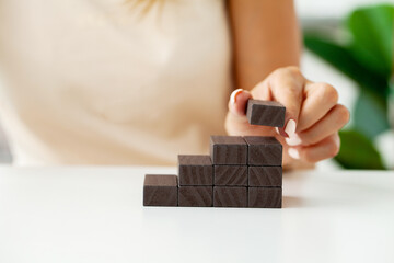 Women hand put wooden blocks in the shape of a staircase