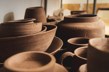 Shelves with bowls, plates, jars, teapots, etc. made in clay in natural raw color until the final painting.