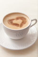 Cup of delicious morning coffee with cinnamon heart