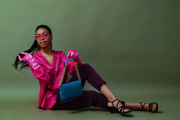 Fashionable elegant Black woman wearing trendy pink sunglasses, fuchsia color blouse, gloves,...