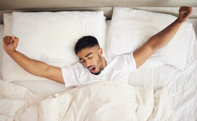 My pillow gives me a new hairstyle every morning. Shot of a young man waking up in a bed at home.