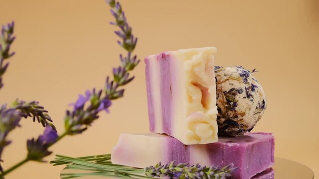 Lavender bath truffles and soap, lavender branches on a beige background. Organic natural soaps and bath bombs with lavender scent. 4k footage
