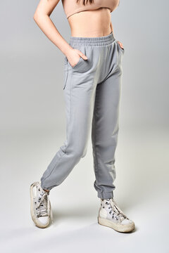 A young girl in grey sweatpants on a white background