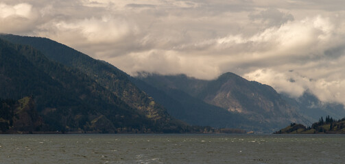Obraz premium Gloomy Mountain Scape across a River of Endless Valley