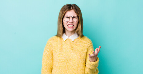 red head pretty woman looking angry, annoyed and frustrated screaming wtf or what’s wrong with you