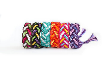 Tied DIY friendship bracelet with unusual braiding pattern on white background