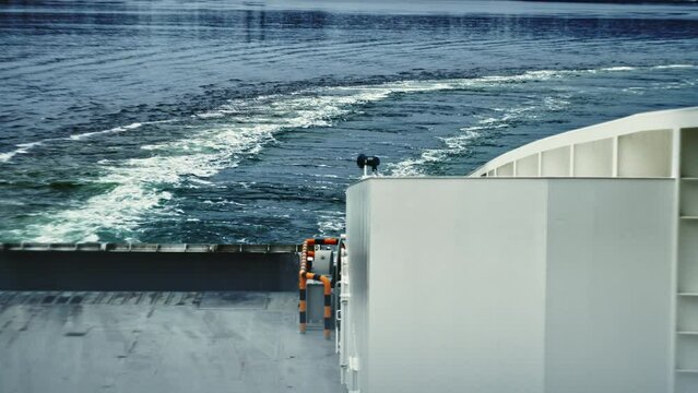 Ferry Travelling Over Water Away From City And Leaving Wake
