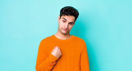 handsome hispanic man looking arrogant, successful, positive and proud, pointing to self