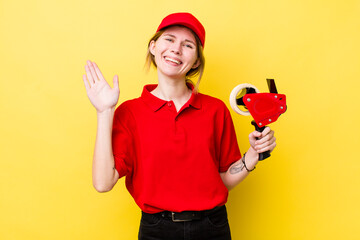 red head pretty woman smiling happily, waving hand, welcoming and greeting you. packer concept