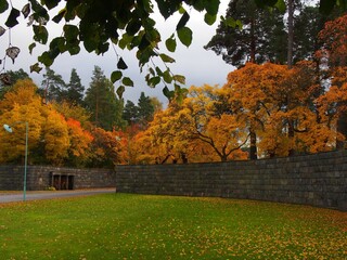 The entrance of Skogskyrkogården Cemetery in autumn with colorful leaves of the trees, Stockholm...
