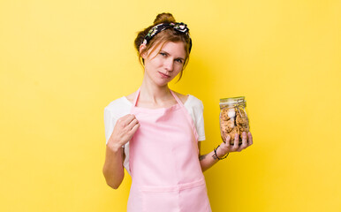 red head pretty woman looking arrogant, successful, positive and proud. housewife holding a cookies...
