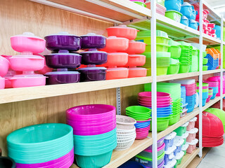 Various type and color plastic household products on supermarker shelf.