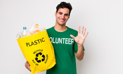 handsome hispanic man smiling and looking friendly, showing number five. ecology concept