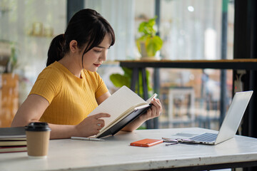 Asian women Work on laptops, computers, and tiger skins at the desk. Small business owners, employees, online, freelance, SME marketing, eCommerce, finance, office marketing ideas.