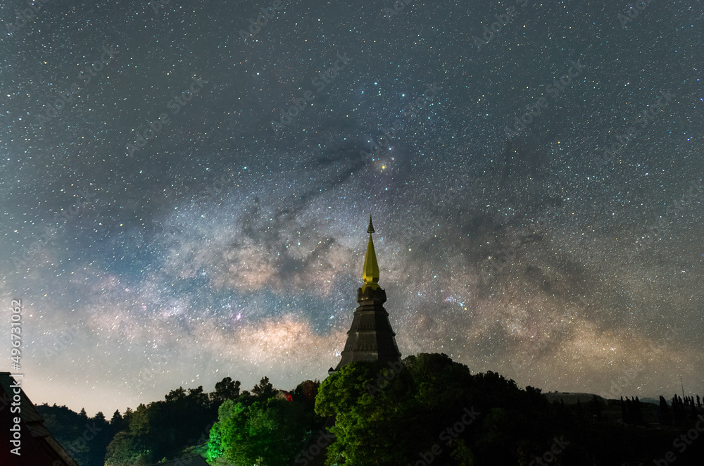Wall mural the milky way galaxy moving over a sacred temple at doi inthanon national park, chiang mai, thailand