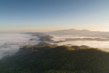 Fog in the morning forest with green mountains and high voltage pole. Pang Puai, Mae Moh, Lampang,...