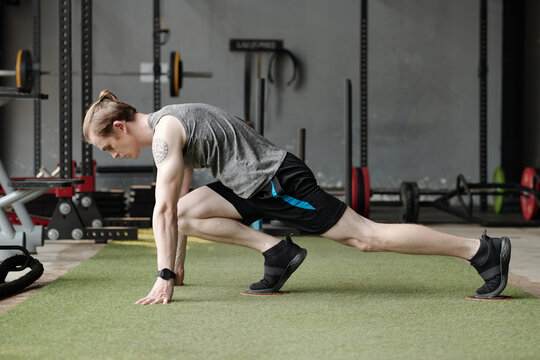 Fit Young Man Doing Exercise With Gliding Discs To Improve Stability.