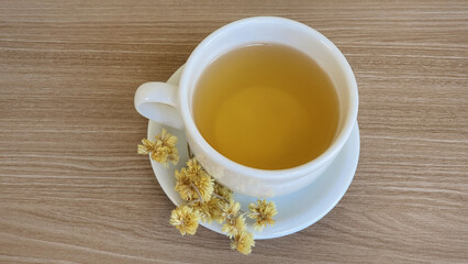 A cup of hot tea made with Macela flowers (Achyrocline satureioides), and Macela flowers on the...