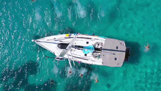 Top view of young friends jumping from sailboat. Yachting. Sail boat party day. Summer luxury boat trip