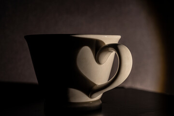 Heart shaped shadow on coffee cup.
