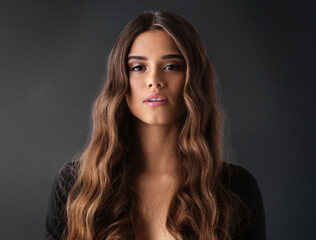 Now thats called a good hair day. Studio shot of a beautiful young woman against a dark background.
