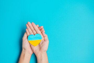 Support for Ukraine in the war with Russia, Hands holding symbol of Heart with flag of Ukraine. Pray, No war, stop war and  stand with Ukraine