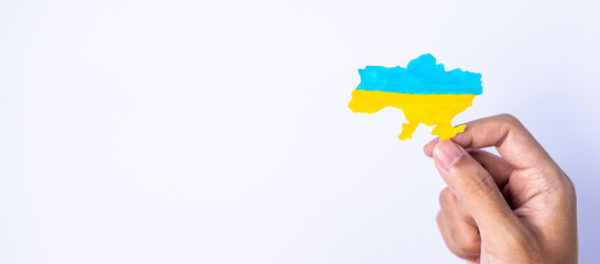 Support for Ukraine in the war with Russia, Hands holding the shape of Ukraine border with color flag. Pray, No war, stop war and stand with Ukraine