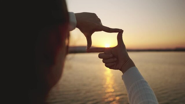 B roll - Close up of woman hands making frame gesture with sunset, New year planning and vision concept, Female capturing the sunrise.