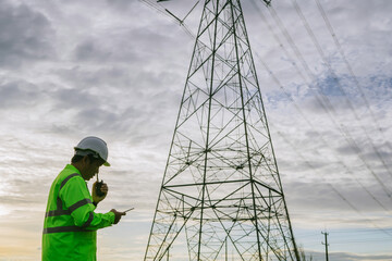 High-voltage engineers use drones and tablets to inspect high-voltage poles.