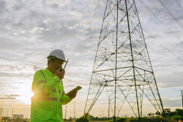 High-voltage engineers use drones and tablets to inspect high-voltage poles.