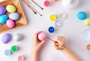 Child paints eggs for easter