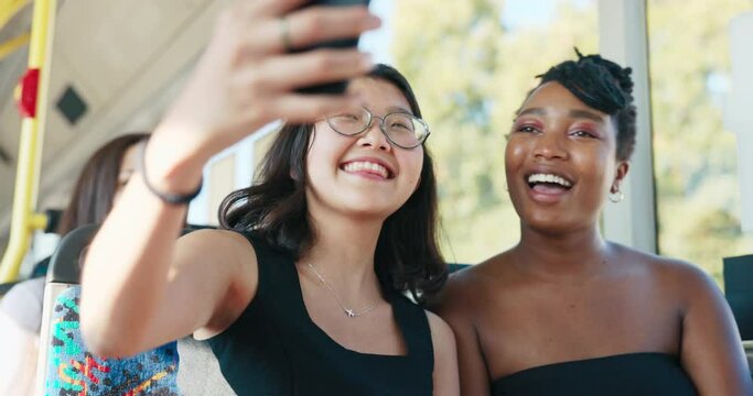 Two beautiful women of different nationalities ride a bus, students return from university in a public transport vehicle, a girl of Asian beauty takes a selfie with a friend