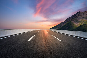 Asphalt road and mountain with beautiful sky clouds at sunrise