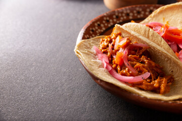 Tacos de Cochinita Pibil. Typical Mexican stew from Yucatan, made from pork marinated with achiote and generally accompanied with beans and red onion with habanero chili